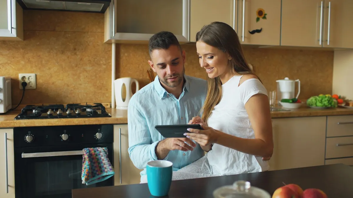 Casal na cozinha conferindo finanças no tablet